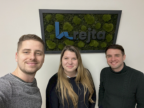 Project manager, project manager and CEO under the Krejta logo hanging on the wall